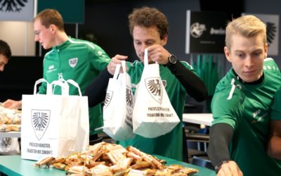 Gemeinsam die Aufholjagd starten: Mannschaft packt Lunchpakete für die Fans